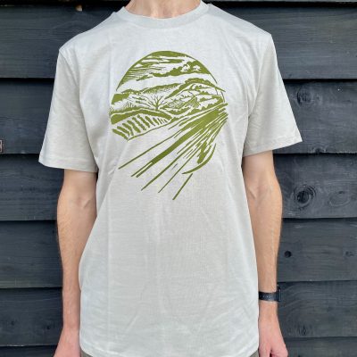 FARMERS' t shirt sage background and green linocut print of lavender fields, worn by a man