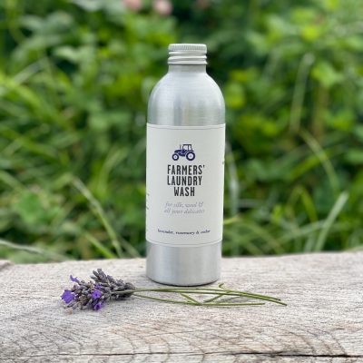 FARMERS Laundry Wash on wood bench with lavender sprigs in front of grassy bank