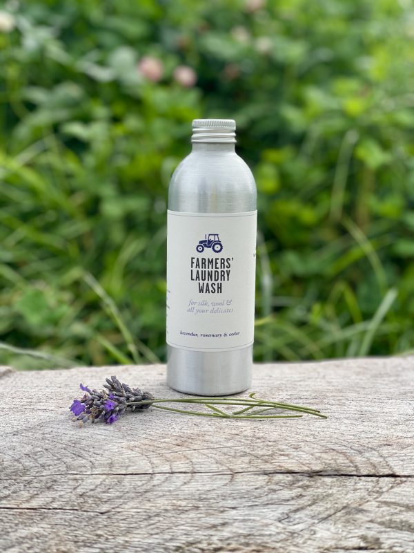 FARMERS Laundry Wash on wood bench with lavender sprigs in front of grassy bank