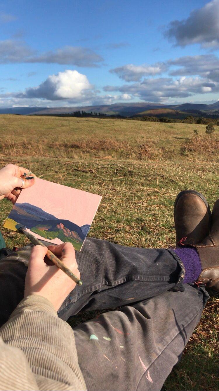 Jess Hinsley painting mountain scene for the 2025 calendar