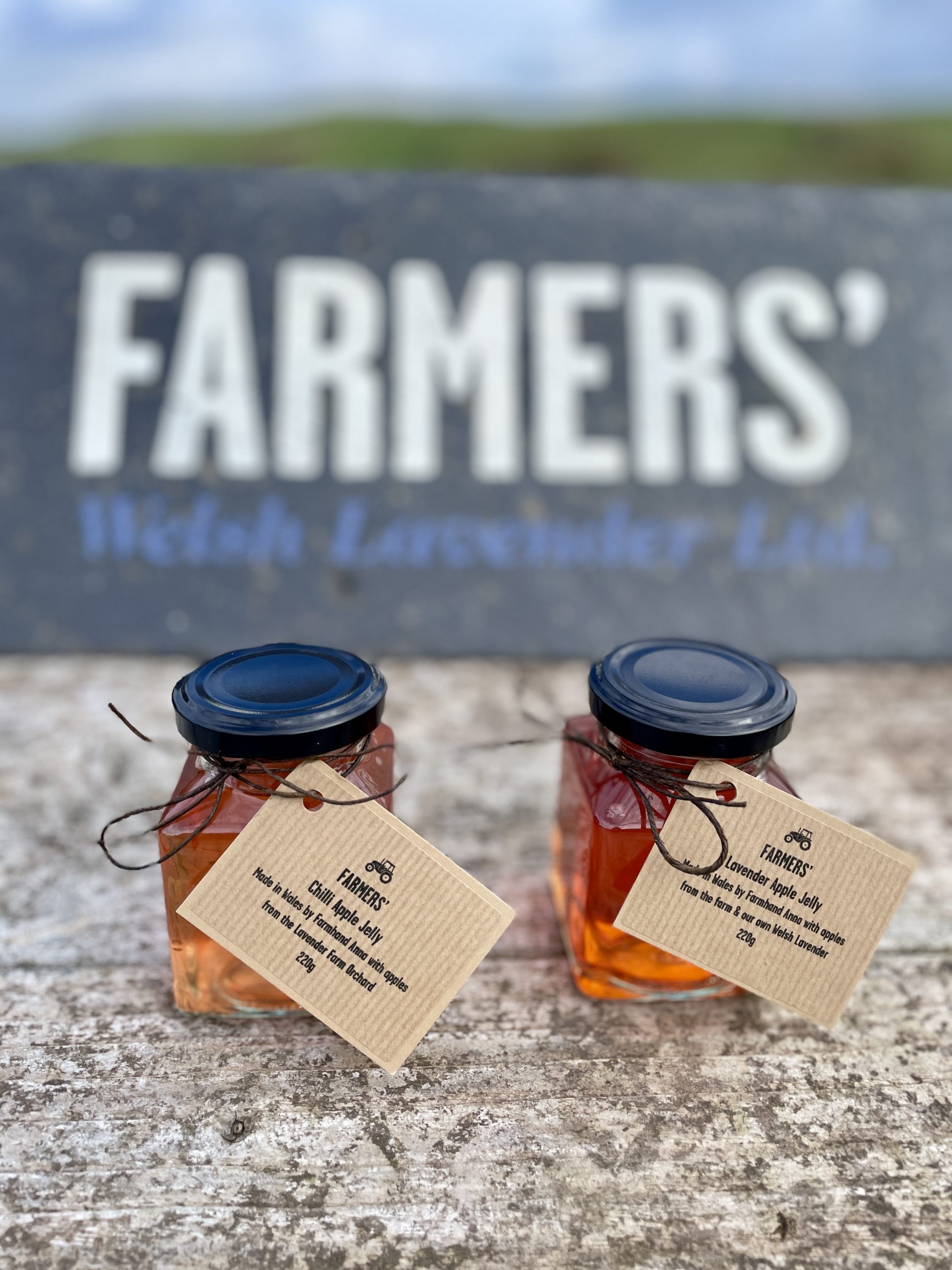 Two jars of Apple Jelly sat in front of a FARMERS' Welsh Lavender sign