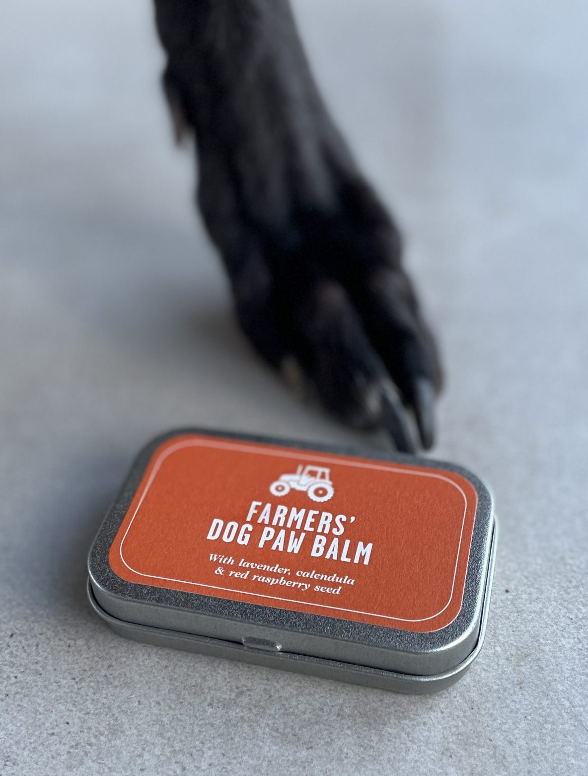 FARMERS' Dog Paw Balm next to a dog paw