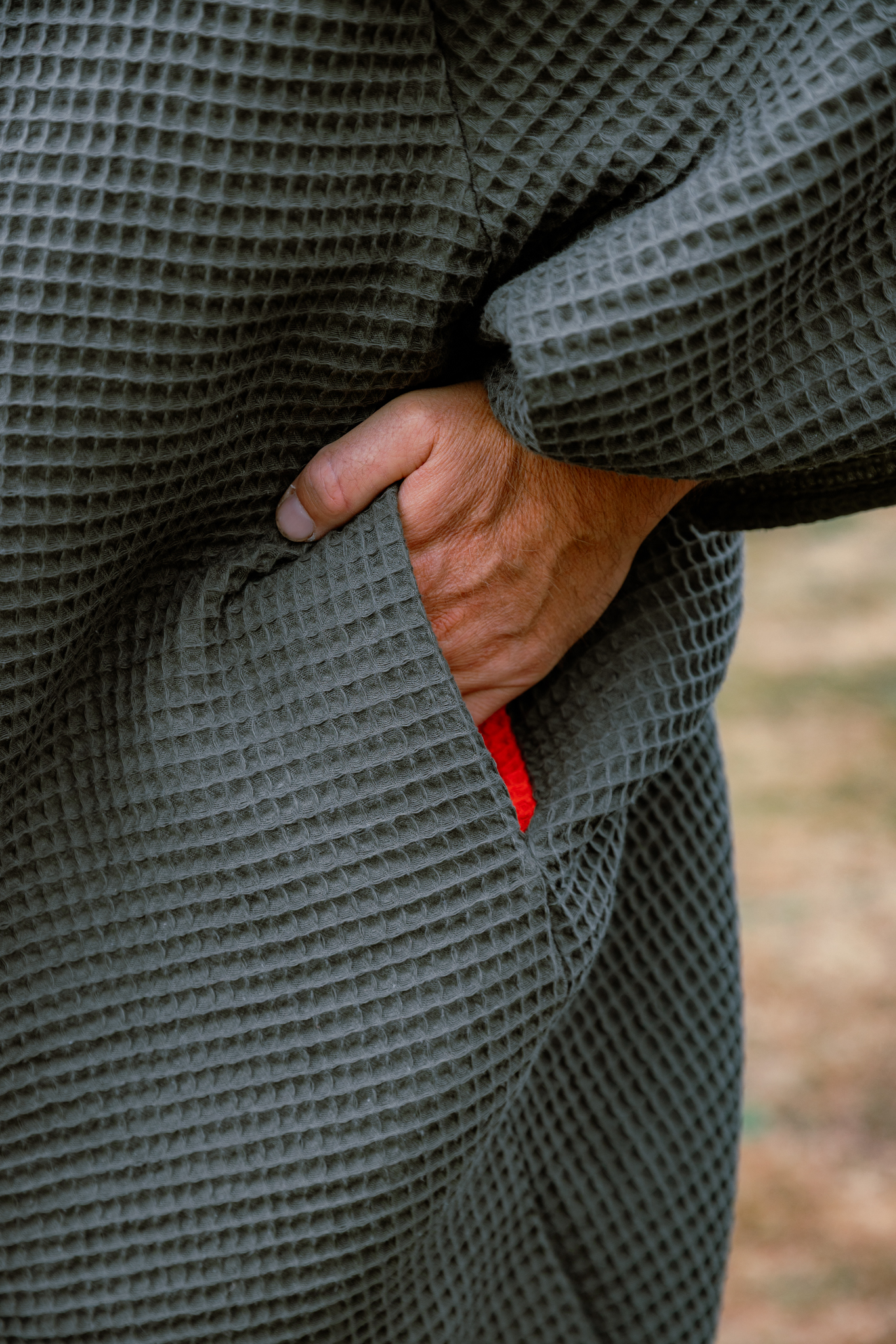 Hand in FARMERS' Waffle robe pocket in army green with orange inside pocket